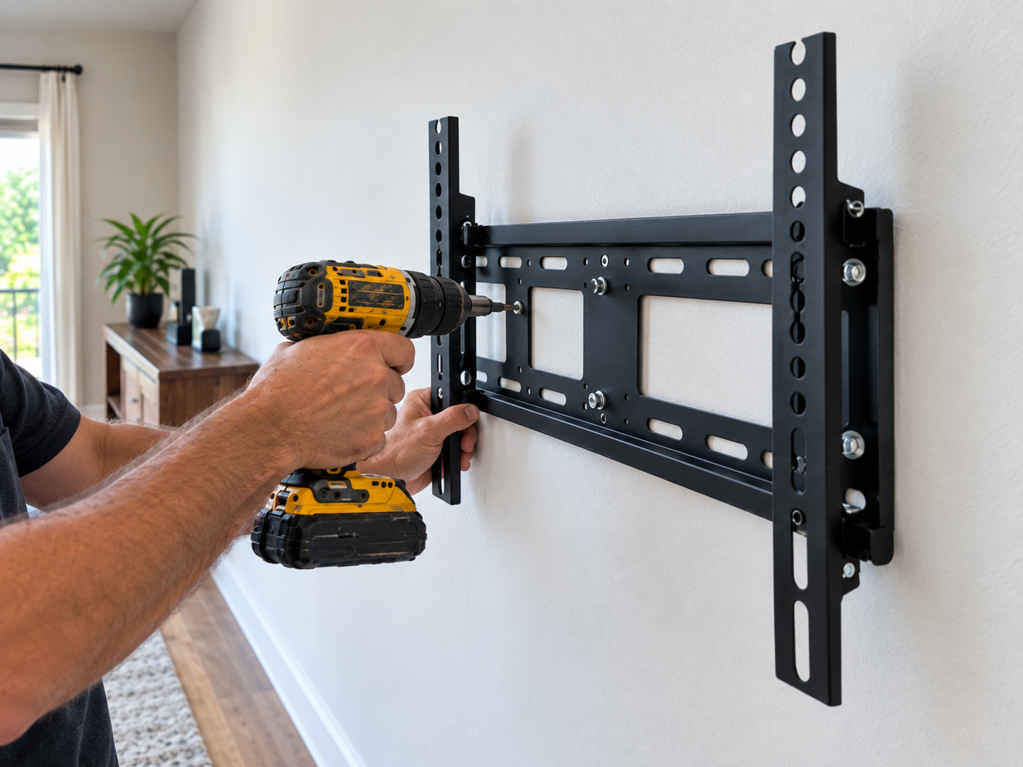 Handyman drilling a TV wall mount bracket into place